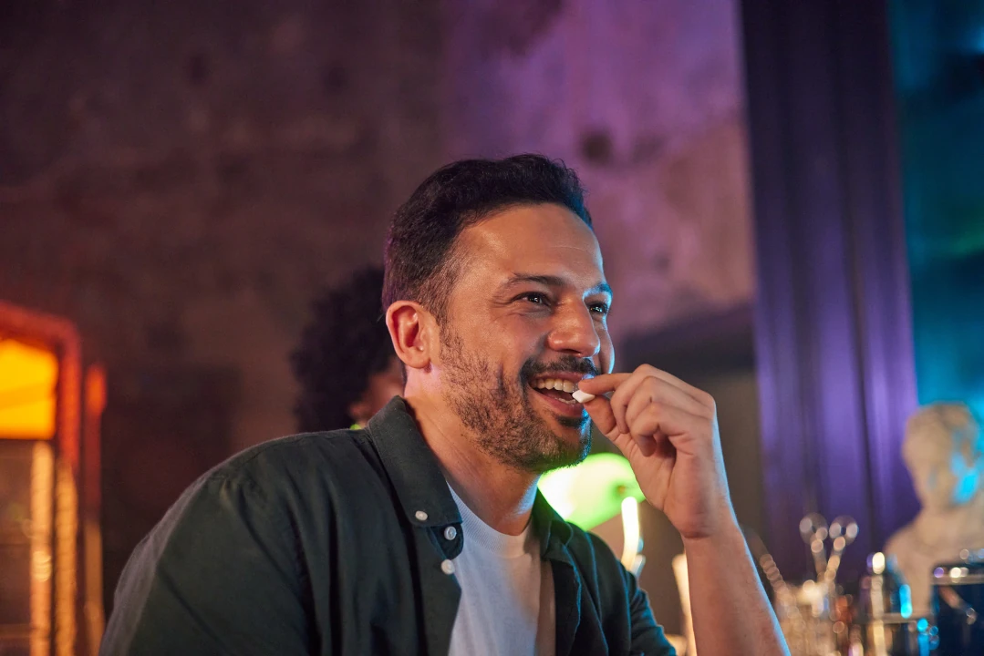 A Man Placing NICORETTE Smoking Cessation Gum in his Mouth